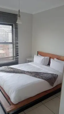 a large bed in a room with a window at 2 Bedroom Penthouse at The Blyde in Pretoria