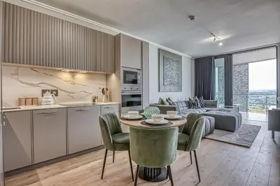 a kitchen and a living room with a table and chairs at Bella Vista at Ellipse in Midrand