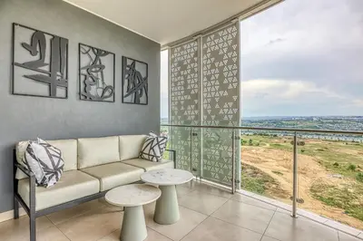 a living room with a couch and a large window at Bella Vista at Ellipse in Midrand