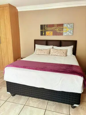 a bedroom with a large bed in a room at Kwamakazi- The Home in Pretoria