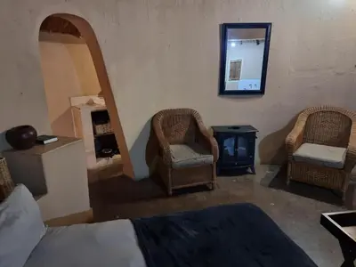 a bedroom with two chairs and a bed and a mirror at Out of Africa Lodge in Hartbeespoort