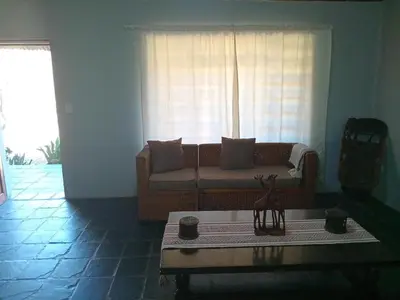a living room with a couch in front of a window at Out of Africa Lodge in Hartbeespoort