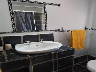 a bathroom with a sink and a mirror at Out of Africa Lodge in Hartbeespoort