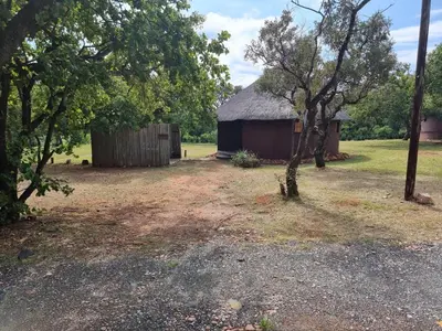 a barn in the middle of a field with trees at Out of Africa Lodge in Hartbeespoort