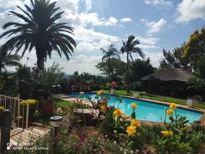 a swimming pool in a garden with flowers at Viva-Africa Zehetleitner in Pretoria