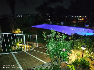 a pathway leading to a swimming pool at night at Viva-Africa Zehetleitner in Pretoria