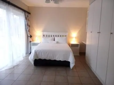 a bedroom with a white bed with white sheets and pillows at African Nights Barbara House in Pretoria
