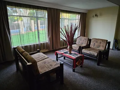 a living room with two chairs and a coffee table at African Nights Barbara House in Pretoria