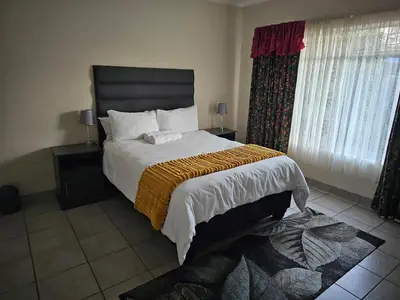 a bedroom with a large bed and a window at African Nights Barbara House in Pretoria