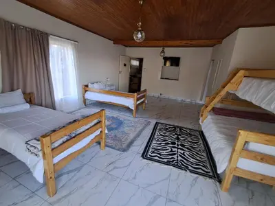 a bedroom with two beds and a television in it at African Nights Barbara House in Pretoria