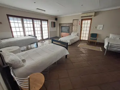 a room with two beds and a tv in it at African Nights Protea House in Pretoria