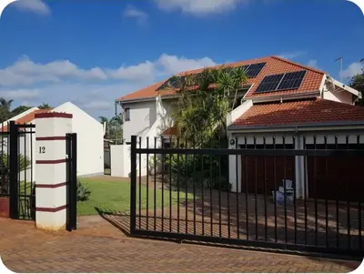 a house with a gate with solar panels on it at African Nights Protea House in Pretoria