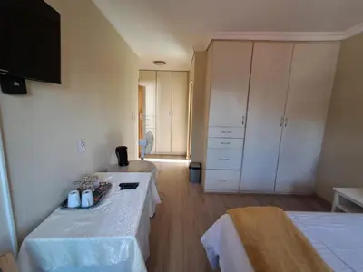 a room with two beds and white cabinets at African Nights Protea House in Pretoria