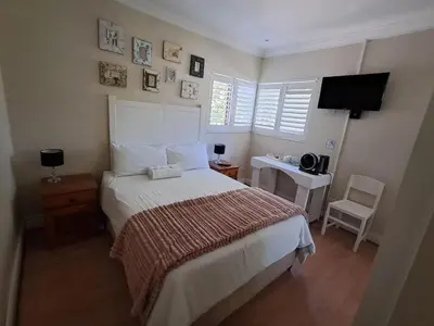a bedroom with a large bed and a television at African Nights Protea House in Pretoria