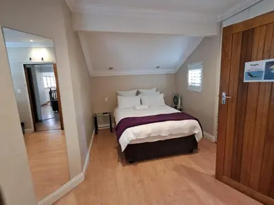a bedroom with a large bed with white pillows at African Nights Protea House in Pretoria