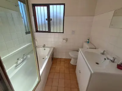 a bathroom with a tub and a sink and a toilet at African Nights Protea House in Pretoria