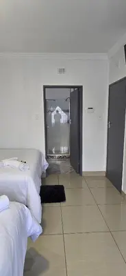 a room with four beds and a room with a mirror at Good night guest house in Polokwane