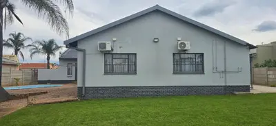 a white house with two windows and a yard at Good night guest house in Polokwane