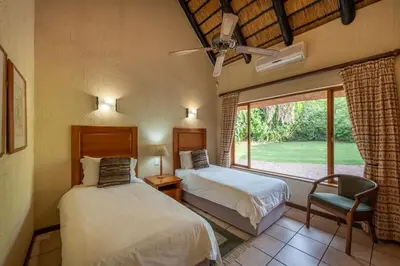 two beds in a room with a window at Kruger Park Lodge Unit No 440 in Hazyview