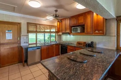 a kitchen with wooden cabinets and a granite counter top at Kruger Park Lodge Unit No 440 in Hazyview