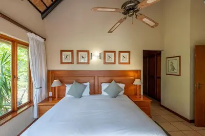 a bedroom with a large bed with a ceiling fan at Kruger Park Lodge Unit No 440 in Hazyview