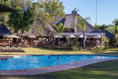 a pool at a resort with people swimming in it at Kruger Park Lodge Unit No 440 in Hazyview