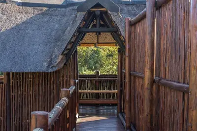 an entrance to a wooden building with a thatch roof at Kruger Park Lodge Unit No 440 in Hazyview