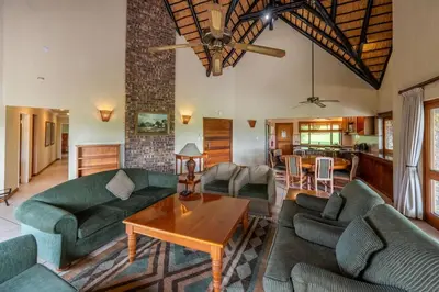 a living room with green couches and a table at Kruger Park Lodge Unit No 440 in Hazyview