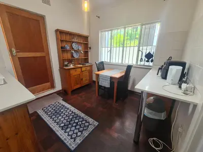 a small kitchen with a table and a door at Amourette's Cottages in Centurion