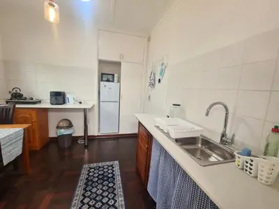 a kitchen with a sink and a refrigerator at Amourette's Cottages in Centurion