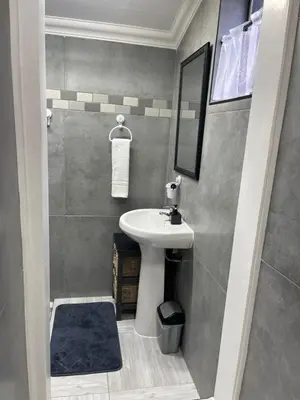 a small bathroom with a sink and a mirror at Luigi's Place in Pretoria