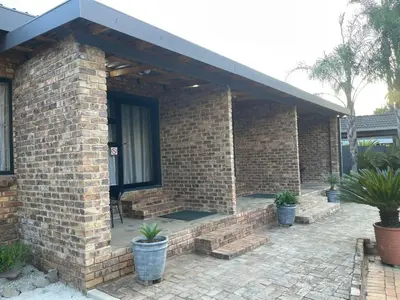 a brick house with a porch and a window at Luigi's Place in Pretoria