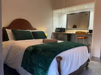 a bedroom with a large bed and a desk at Luigi's Place in Pretoria
