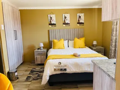 a bedroom with a large bed with yellow pillows at Dabase manor