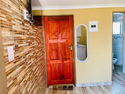 a bathroom with a red door and a mirror at Dabase manor