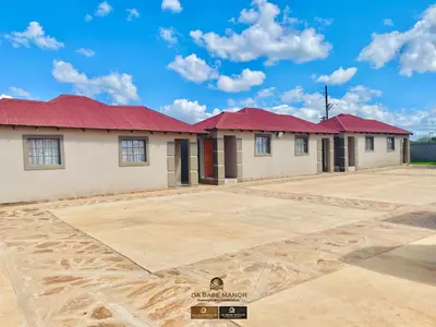a row of houses with red roofs on a dirt lot at Dabase manor