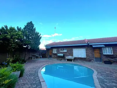 a swimming pool in the yard of a house at Olive's Quaint in Polokwane