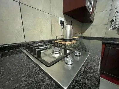 a kitchen with a stove top oven in a kitchen at Olive's Quaint in Polokwane
