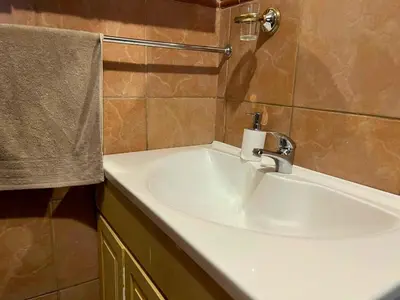 a bathroom with a white sink and a towel at Olive's Quaint in Polokwane