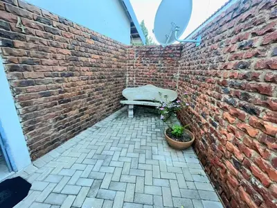 a brick wall with a bench against a brick wall at Olive's Quaint in Polokwane