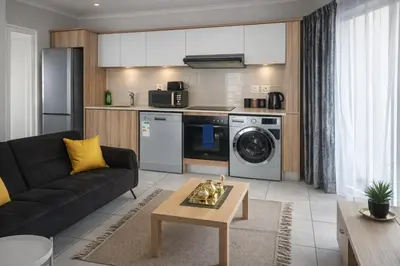 a living room with a couch and a kitchen at The Blydes Crystal Lagoon in Pretoria