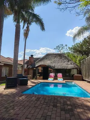 a house with a swimming pool and palm trees at Macibela2 in Bela-Bela