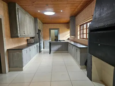 a large kitchen with gray cabinets and a tile floor at Lula Guest house 14km to Kriel power station in Kriel