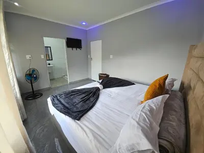 a bedroom with a large bed with pillows on it at Lula Guest house 14km to Kriel power station in Kriel