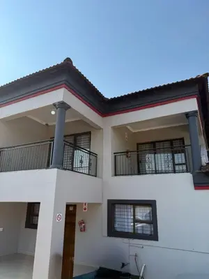 a white house with two balconies on top of it at Amai Guesthouse in Thohoyandou