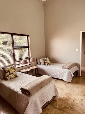 a room with two beds and a window at Schaapkraal Cottages in Weimershoek
