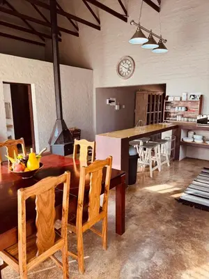 a kitchen and dining room with a wooden table and chairs at Schaapkraal Cottages in Weimershoek