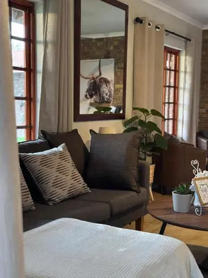 a living room with a couch and a table at EquiRest Horse & Human Country Stay in Midrand