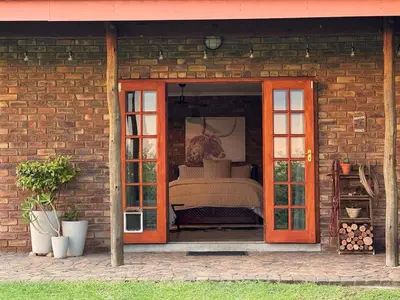 a room with a bed inside of a brick building at EquiRest Horse & Human Country Stay in Midrand