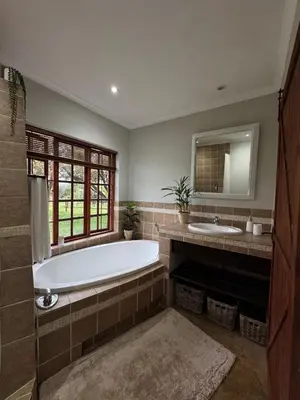 a large bathroom with a tub and a sink at EquiRest Horse & Human Country Stay in Midrand